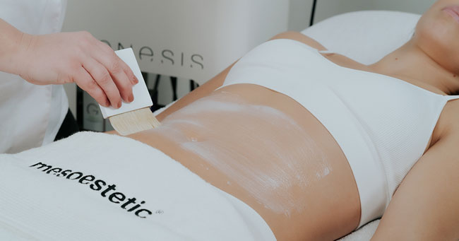 soin cosmétique minceur appliqué sur le ventre par une esthéticienne