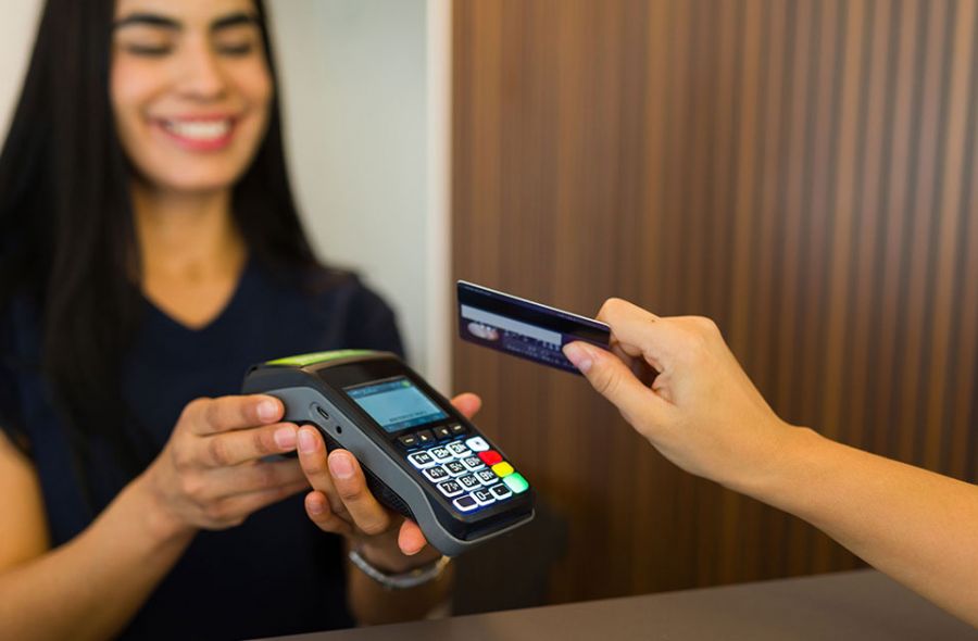 esthéticienne souriante encaisse le prix de ses prestations dans un institut de beauté