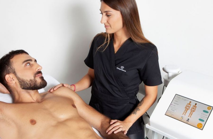 un esthéticienne retient un client avec un appareil minceur efficace